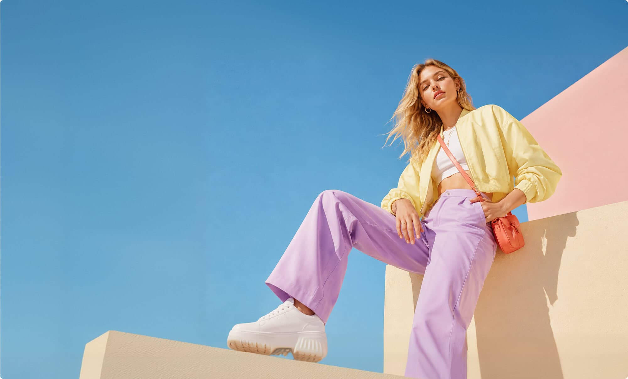 Woman in a neutral outfit against a blue sky, representing colour-season styling